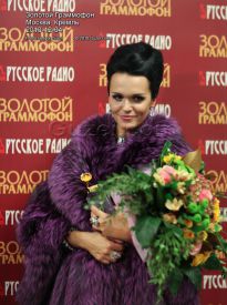 Певица Слава в фиолетовой шубе и с цветами - фото